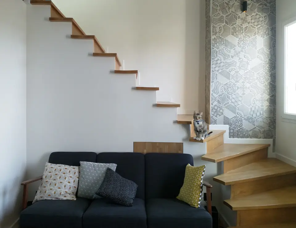Canapé au pied de l'escalier bois et carreaux de ciment