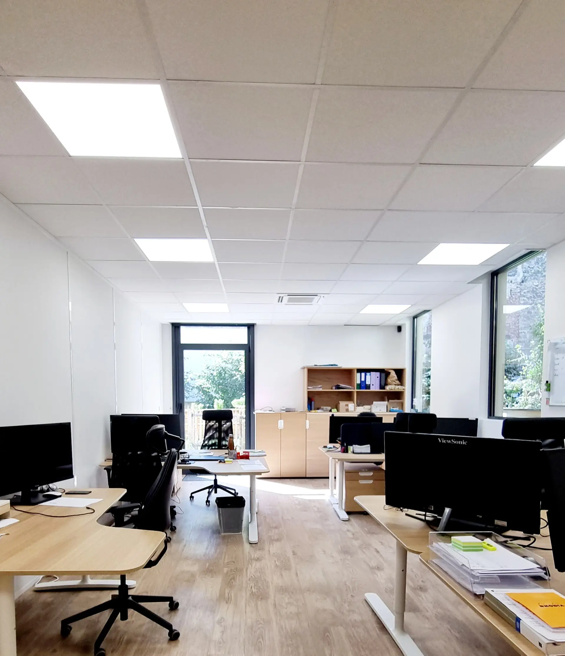 Open space réaménagé, postes de travail près de la fenêtre