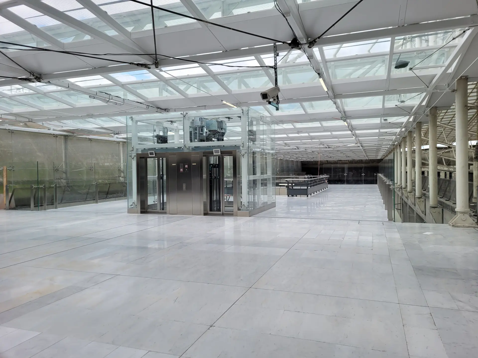 Hall vitré et ascenseur panoramique sous la couverture verrière