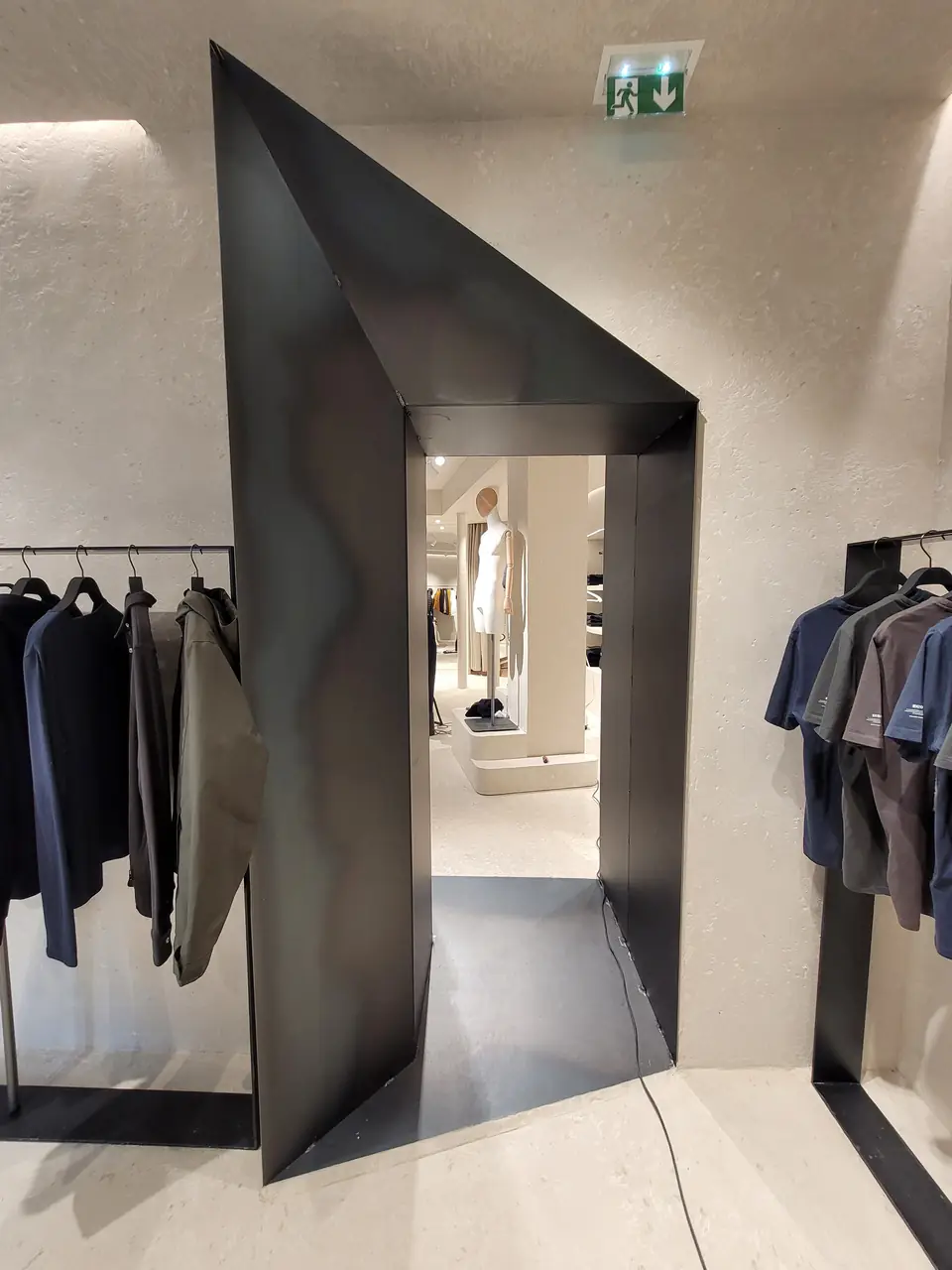 Paso de chapa metálica negra plegada hacia el fondo de la tienda