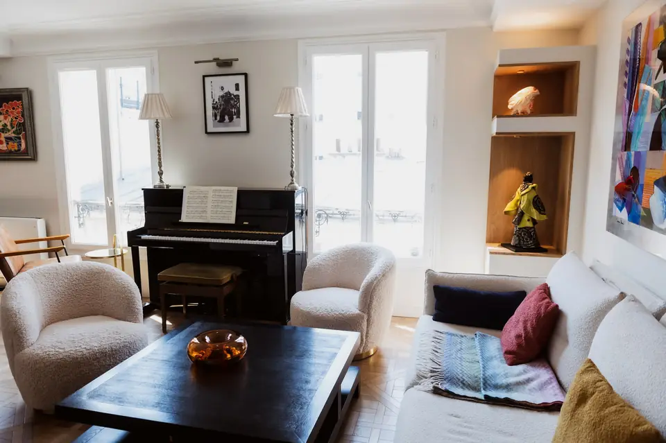 Coin salon avec piano droit et fauteuils, parquet en point de Hongrie
