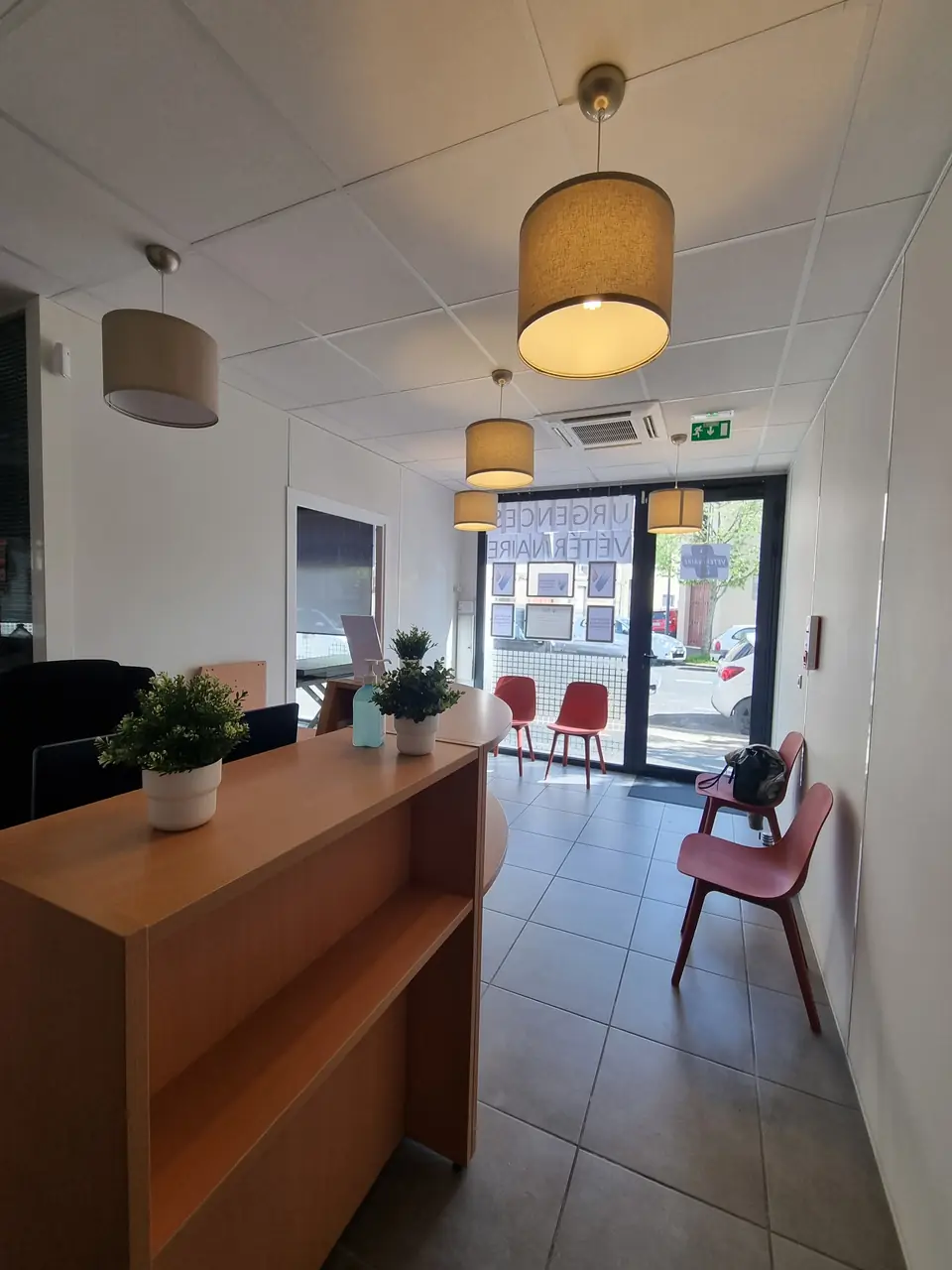 Espace d'accueil et d'attente, comptoir bois et assises rouges